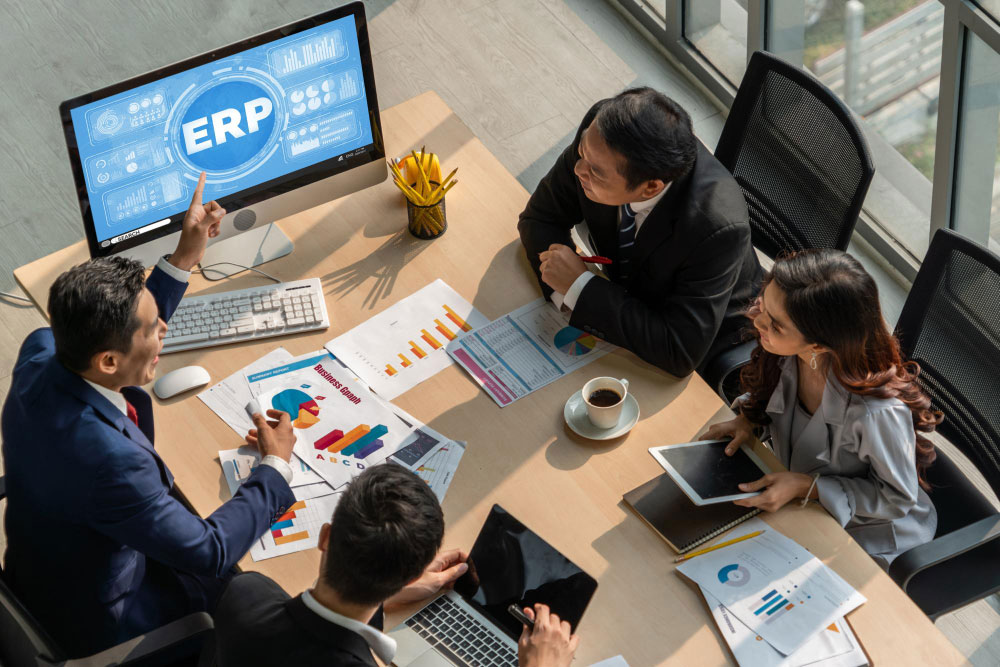 Equipo de trabajo revisando un sistema ERP durante una reunión para gestionar procesos empresariales y evaluar su integración con automatización.