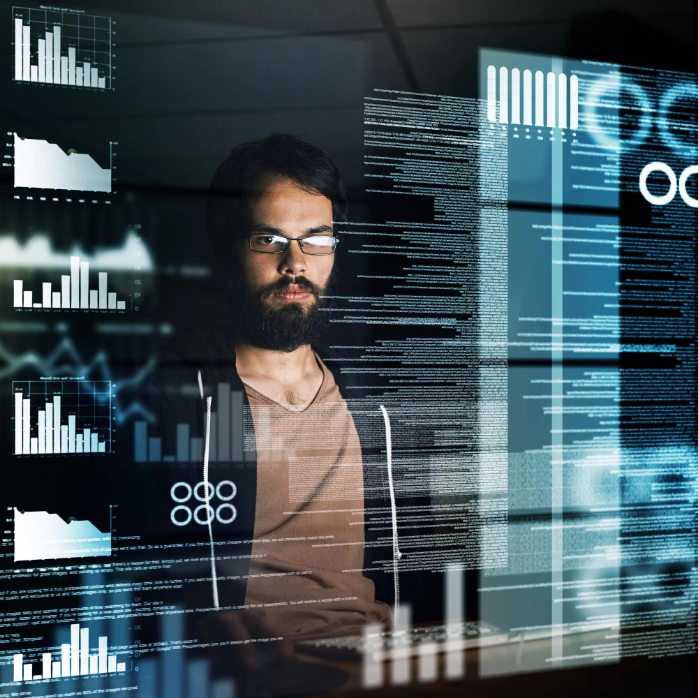 Desarrollador frente a pantallas con gráficos y código, simbolizando soluciones de IA para extracción inteligente de datos