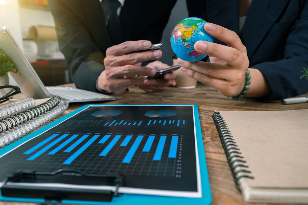 Gráfica de barras y globo terráqueo ilustrando la comparación de horas trabajadas y productividad global