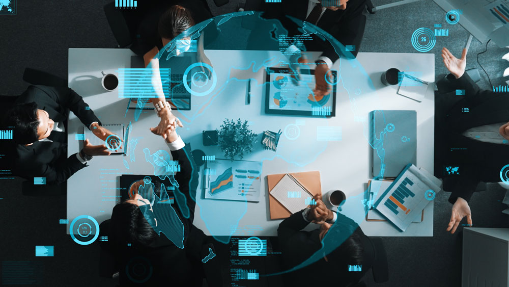 Vista cenital de un equipo de trabajo reunido, discutiendo la nueva jornada laboral