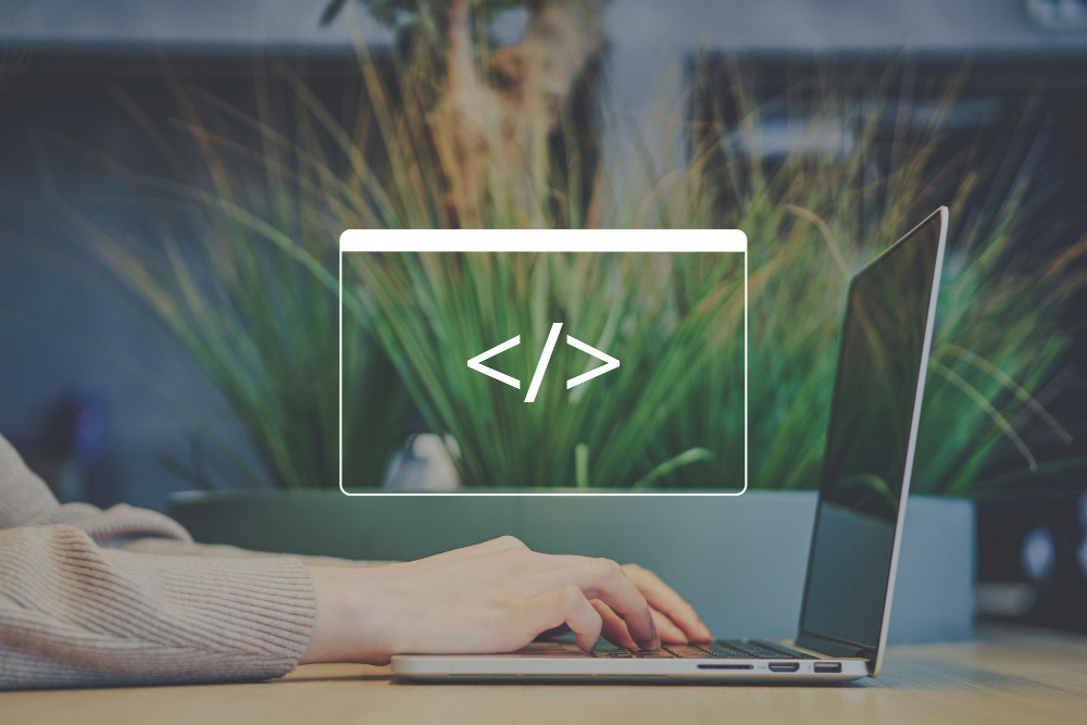 Persona trabajando en un portátil con ícono de código, representación visual del concepto de low code.