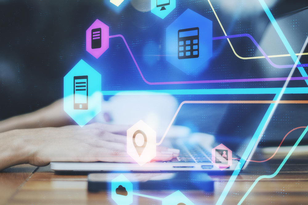 Contador trabajando en un portátil mientras sobresalen iconos que representan la facturación electrónica en Colombia