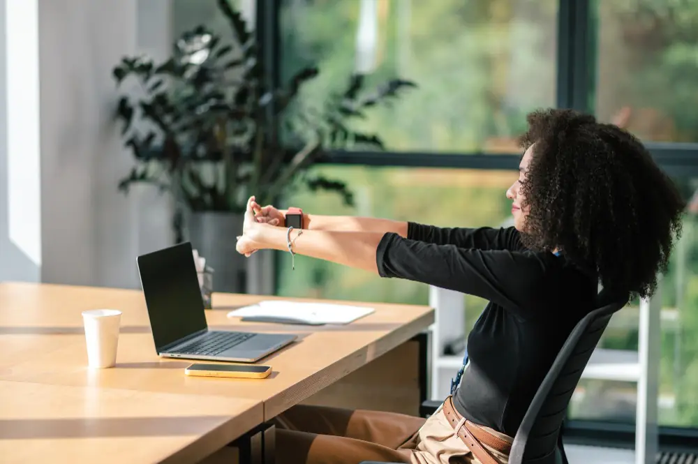 Persona levantándose, estirándose y haciendo una pausa en su trabajo